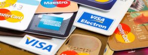 Close-up view of several VISA, MasterCard, and Amex credit cards strewn across a table