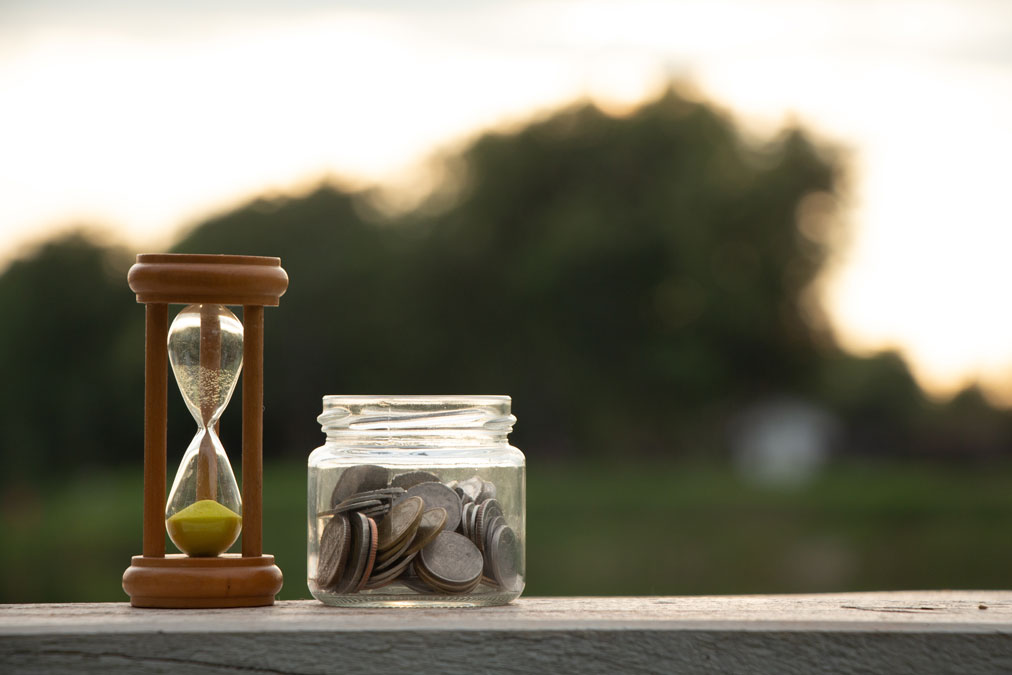Hourglass and jar of coins representing an urgent cash loan Singapore