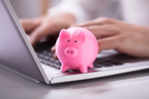 Piggy bank on laptop representing instant online loan in Singapore